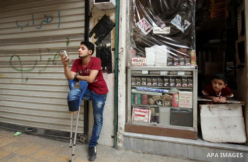 Nour, a 18-year-old Syrian man, stands in a street in a rebel-controlled area of Aleppo, on August 13, 2015. Nour lost his leg following a bomb barrel attack by forces of Syria's President Bashar al-Assad near his house...