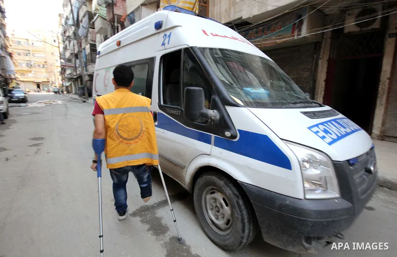 Nour, a 18-year-old Syrian man, walks next to an ambulance, in a rebel-controlled area of Aleppo, on August 13, 2015. Nour lost his leg following a bomb barrel attack by forces of Syria's President Bashar al-Assad near h...