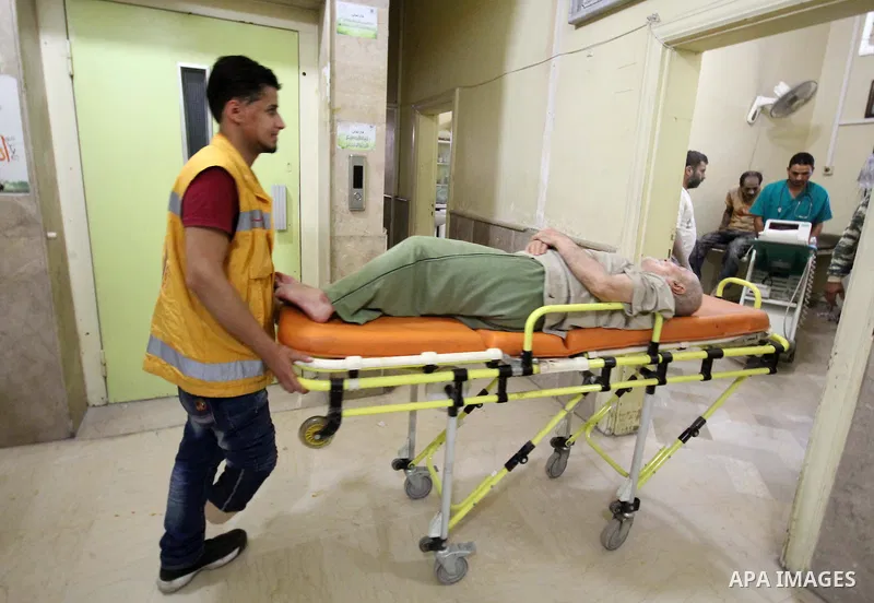 Nour, a 18-year-old Syrian man, helps a wounded man in a hospital, in a rebel-controlled area of Aleppo, on August 13, 2015. Nour lost his leg following a bomb barrel attack by forces of Syria's President Bashar al-Assad...
