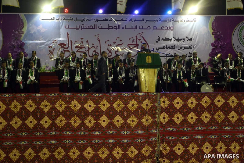 Palestinian grooms sit on the stage during a mass wedding for 53 couples in Khan Younis in the southern Gaza Strip August 13, 2015. The wedding was funded by the Islamic Society. Photo by Abed Rahim Khatib