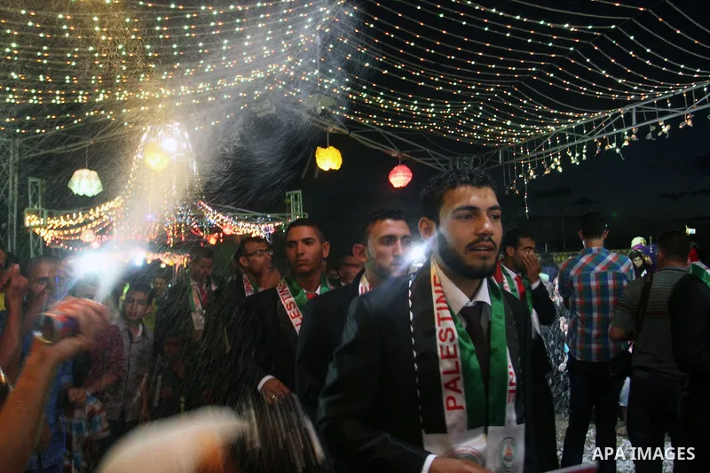 Palestinian grooms take part in a mass wedding for 53 couples in Khan Younis in the southern Gaza Strip August 13, 2015. The wedding was funded by the Islamic Society. Photo by Abed Rahim Khatib