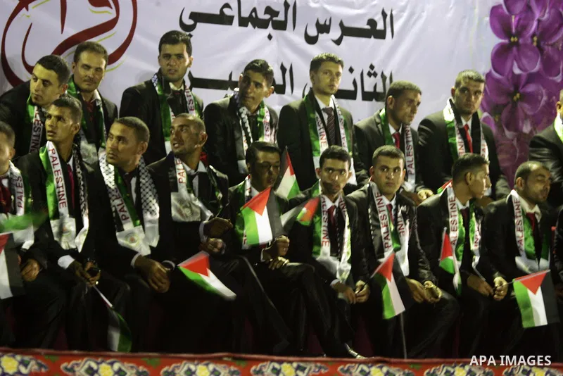Palestinian grooms sit on the stage during a mass wedding for 53 couples in Khan Younis in the southern Gaza Strip August 13, 2015. The wedding was funded by the Islamic Society. Photo by Abed Rahim Khatib