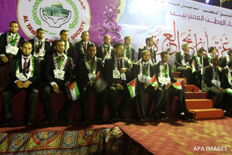 Palestinian grooms sit on the stage during a mass wedding for 53 couples in Khan Younis in the southern Gaza Strip August 13, 2015. The wedding was funded by the Islamic Society. Photo by Abed Rahim Khatib