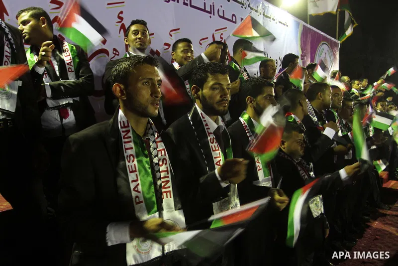 Palestinian grooms sit on the stage during a mass wedding for 53 couples in Khan Younis in the southern Gaza Strip August 13, 2015. The wedding was funded by the Islamic Society. Photo by Abed Rahim Khatib