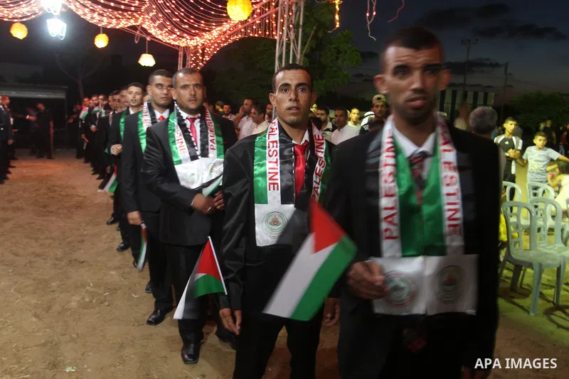 Palestinian grooms take part in a mass wedding for 53 couples in Khan Younis in the southern Gaza Strip August 13, 2015. The wedding was funded by the Islamic Society. Photo by Abed Rahim Khatib