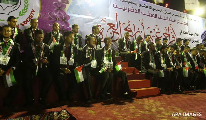 Palestinian grooms sit on the stage during a mass wedding for 53 couples in Khan Younis in the southern Gaza Strip August 13, 2015. The wedding was funded by the Islamic Society. Photo by Abed Rahim Khatib