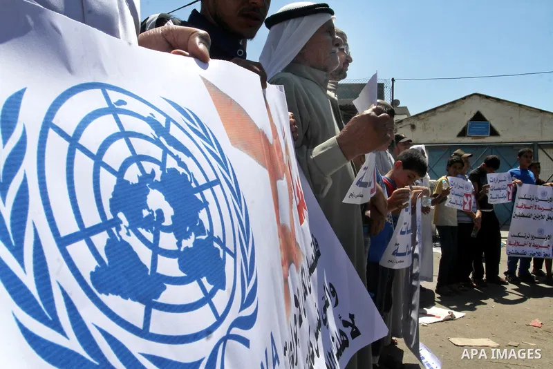 Palestinians take part in a protest against the reduction of educational programs given by the United Nations Relief and Works Agency (UNRWA) outside the UNRWA Office in Rafah in the southern Gaza Strip on August 14, 201...