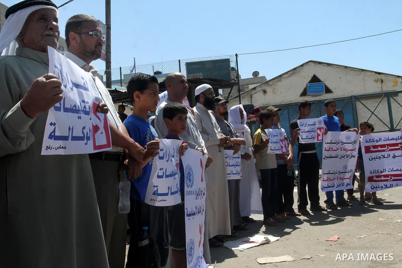 Palestinians take part in a protest against the reduction of educational programs given by the United Nations Relief and Works Agency (UNRWA) outside the UNRWA Office in Rafah in the southern Gaza Strip on August 14, 201...