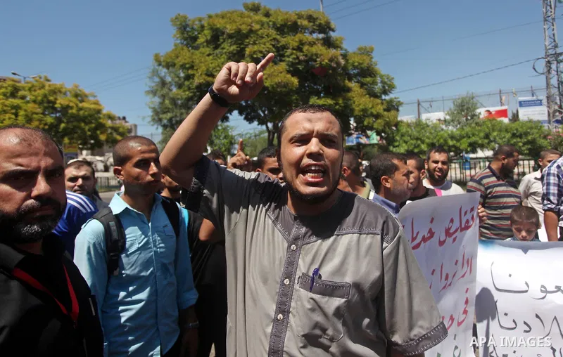 Palestinians take part in a protest against the reduction of educational programs given by the United Nations Relief and Works Agency (UNRWA) outside the UNRWA headquarters in Gaza city on August 14, 2015 . The UNRWA war...