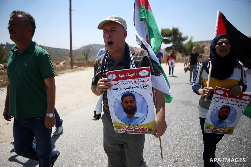 Protesters hold pictures of Palestinian prisoner Mohammad Allan, allegedly being held in an Israeli jail, during a protest in the West Bank village of Nabi Saleh, near Ramallah, 14 August 2015. According to the Palestini...