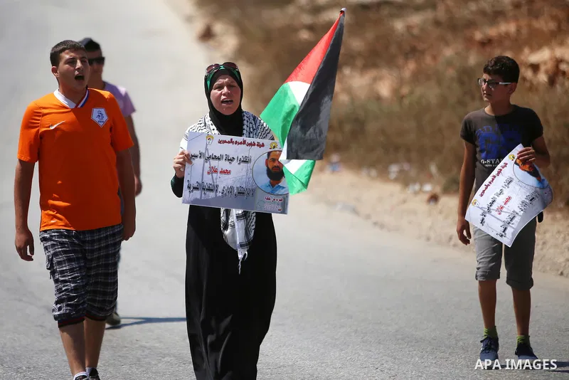 Protesters hold pictures of Palestinian prisoner Mohammad Allan, allegedly being held in an Israeli jail, during a protest in the West Bank village of Nabi Saleh, near Ramallah, 14 August 2015. According to the Palestini...