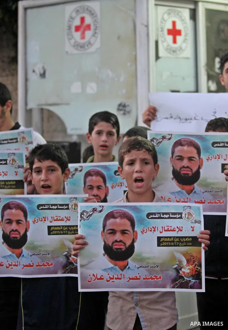 Palestinian children hold pictures of prisoner Mohammad Allan, allegedly being held in an Israeli jail, during a protest outside the Red Cross headquarter, in Gaza city on August 14, 2015. The Israeli military prosecutor...