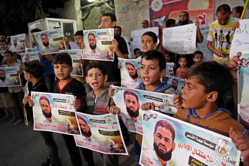 Palestinian children hold pictures of prisoner Mohammad Allan, allegedly being held in an Israeli jail, during a protest outside the Red Cross headquarter, in Gaza city on August 14, 2015. The Israeli military prosecutor...
