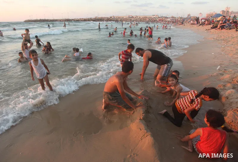 Palestinians enjoy a hot day at the beach of the Mediterranean Sea on the coast of Gaza City on August 14, 2015. Photo by Ashraf Amra