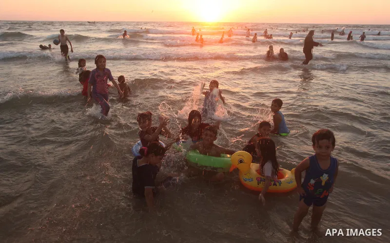 Palestinians enjoy a hot day at the beach of the Mediterranean Sea on the coast of Gaza City on August 14, 2015. Photo by Ashraf Amra