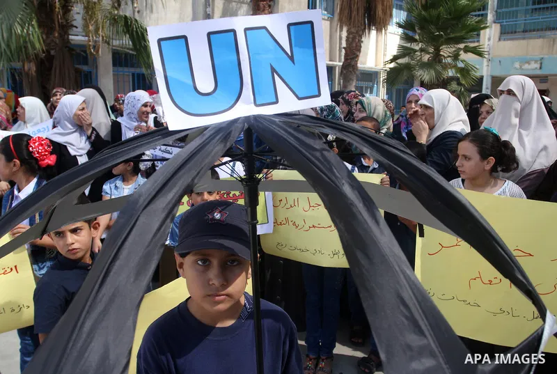 Palestinian children and teachers hold placards during a protest against the reduction of educational programs given by the United Nations Relief and Works Agency (UNRWA) at the Rafah refugee camp in the southern Gaza St...