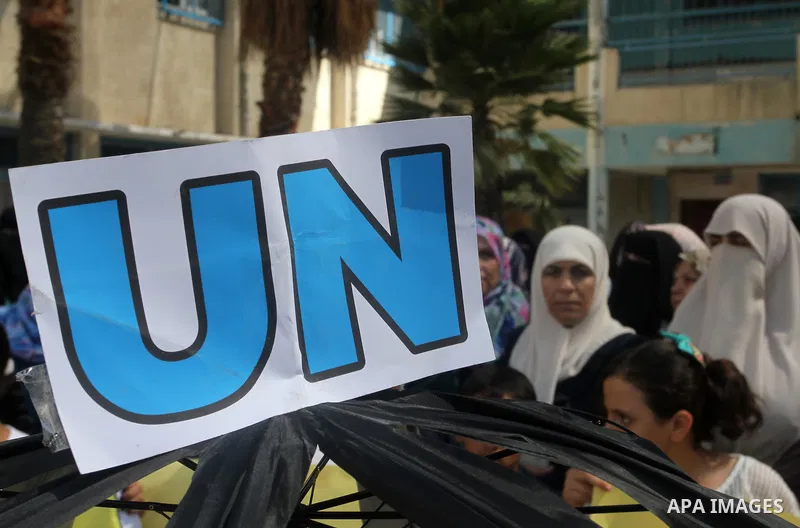 Palestinian children and teachers hold placards during a protest against the reduction of educational programs given by the United Nations Relief and Works Agency (UNRWA) at the Rafah refugee camp in the southern Gaza St...