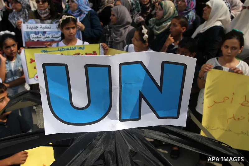 Palestinian children and teachers hold placards during a protest against the reduction of educational programs given by the United Nations Relief and Works Agency (UNRWA) at the Rafah refugee camp in the southern Gaza St...