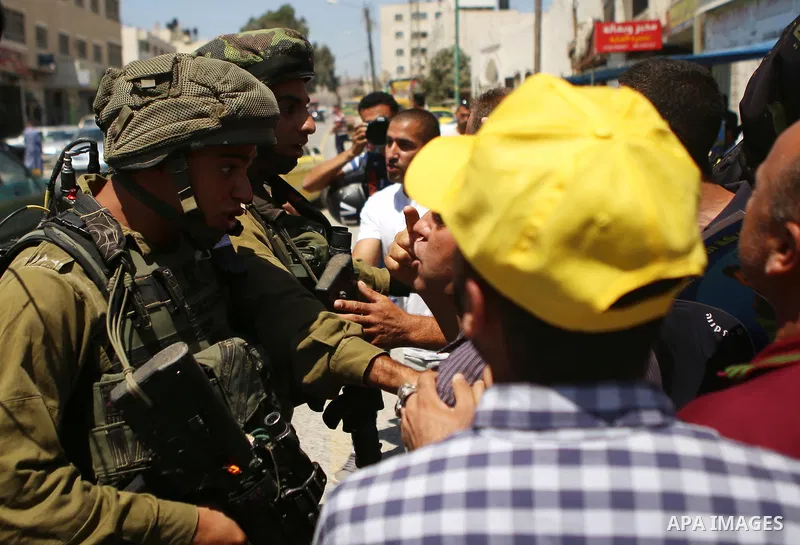 Palestinian protesters argue with Israeli soldiers during a demonstration in solidarity with Palestinian of prisoner Mohammad Allan, allegedly being held in an Israeli jail, at Israeli checkpoint of Hawara, near the West...