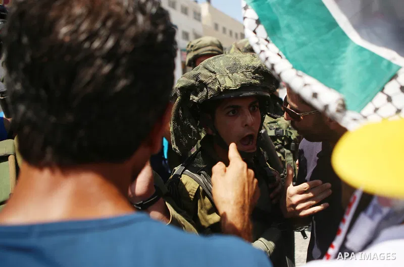 Palestinian protesters argue with Israeli soldiers during a demonstration in solidarity with Palestinian of prisoner Mohammad Allan, allegedly being held in an Israeli jail, at Israeli checkpoint of Hawara, near the West...