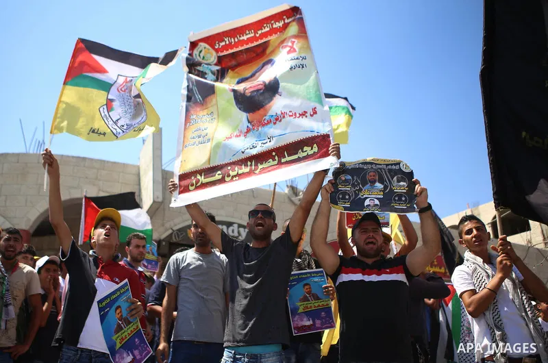 Palestinian protesters shout slogans during a demonstration in solidarity with Palestinian of prisoner Mohammad Allan, allegedly being held in an Israeli jail, at Israeli checkpoint of Hawara, near the West Bank city of...