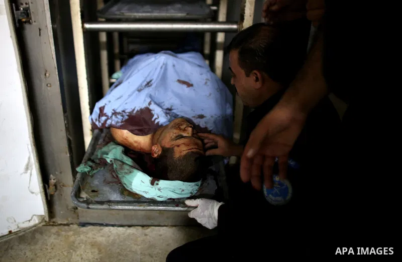Relatives of Rafiq Kamel Al-Taj, a 21-year-old Palestinian man stand over his body at a morgue, in Rafidia Governmental Hospital in the West Bank city of Nablus on August 15, 2015. A police spokesperson said that Israeli...