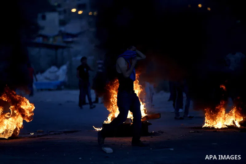 Palestinian protesters burn tires during clashes with Israeli security forces following killed of Rafiq Kamel Al-Taj, in the West Bank village of Beta near Nablus City on August 15, 2015. A police spokesperson said that...