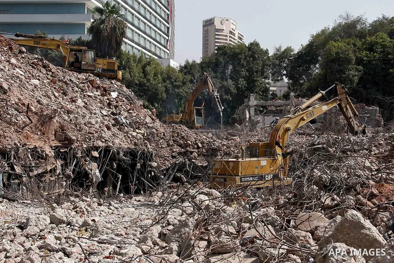 Egyptian workers use a bulldozer during the demolition of the headquarters of the once-dominant party of ex-president Hosni Mubarak that was torched during the 2011 uprising that toppled him, on August 16, 2015 in the ca...