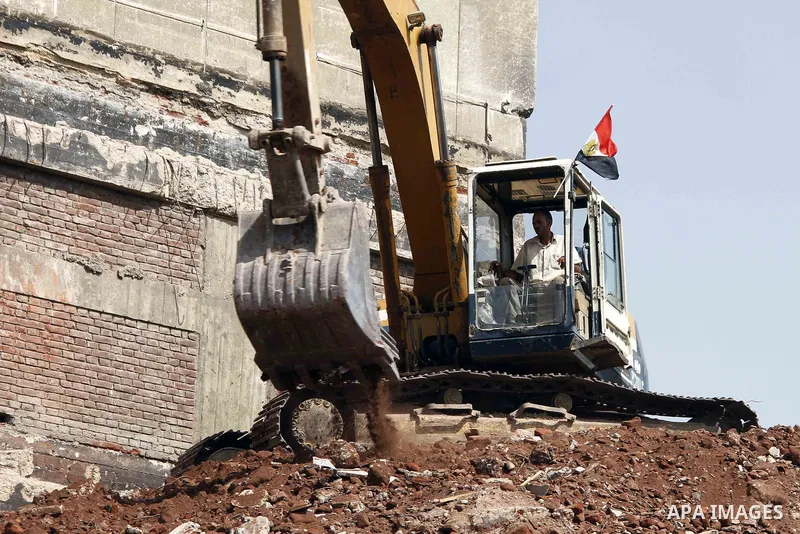 Egyptian workers use a bulldozer during the demolition of the headquarters of the once-dominant party of ex-president Hosni Mubarak that was torched during the 2011 uprising that toppled him, on August 16, 2015 in the ca...