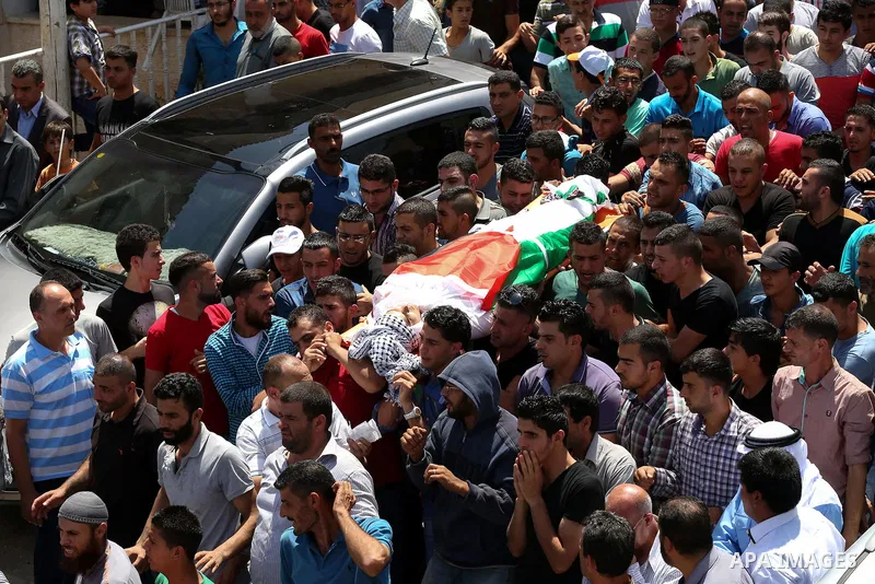 Mourners carry the body of 21-year-old Rafiq Taj, a Palestinian who was shot dead by Israeli forces after stabbing an Israeli border policeman, during his funeral procession on August 16, 2015 near the West Bank village...