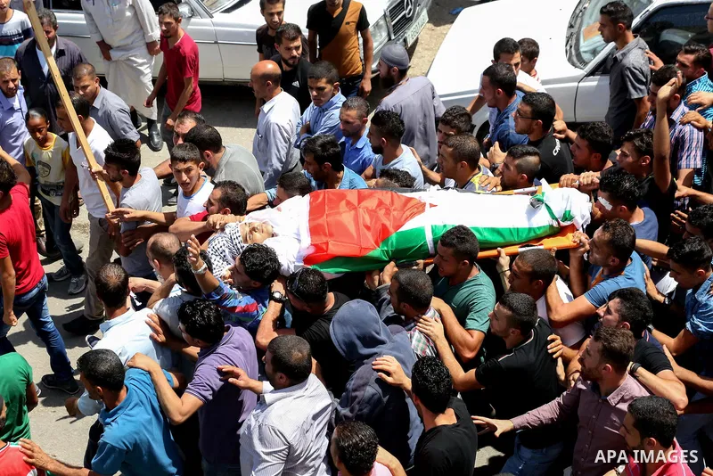 Mourners carry the body of 21-year-old Rafiq Taj, a Palestinian who was shot dead by Israeli forces after stabbing an Israeli border policeman, during his funeral procession on August 16, 2015 near the West Bank village...
