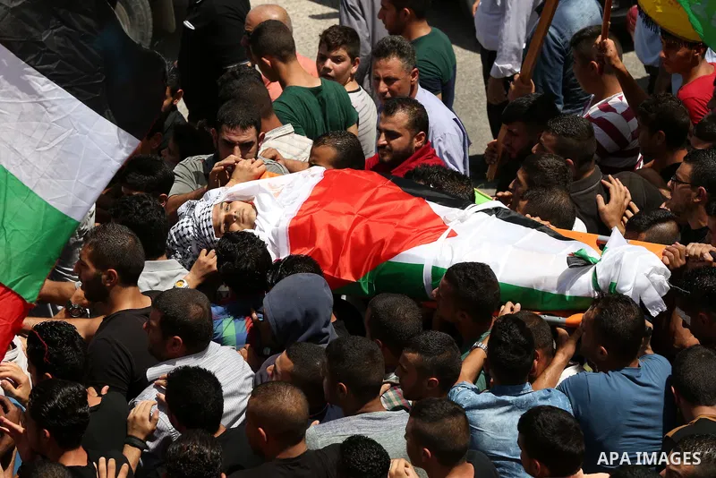 Mourners carry the body of 21-year-old Rafiq Taj, a Palestinian who was shot dead by Israeli forces after stabbing an Israeli border policeman, during his funeral procession on August 16, 2015 near the West Bank village...