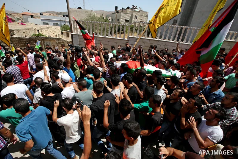 Mourners carry the body of 21-year-old Rafiq Taj, a Palestinian who was shot dead by Israeli forces after stabbing an Israeli border policeman, during his funeral procession on August 16, 2015 near the West Bank village...