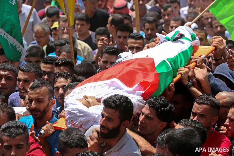 Mourners carry the body of 21-year-old Rafiq Taj, a Palestinian who was shot dead by Israeli forces after stabbing an Israeli border policeman, during his funeral procession on August 16, 2015 near the West Bank village...