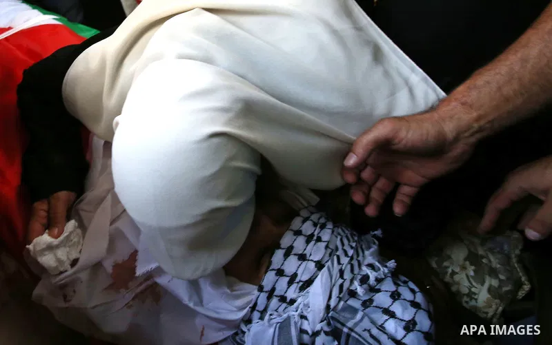 A relatives mourns over the body of 21-year-old Rafiq Taj, a Palestinian who was shot dead by Israeli forces after stabbing an Israeli border policeman, during his funeral on August 16, 2015 near the West Bank village of...