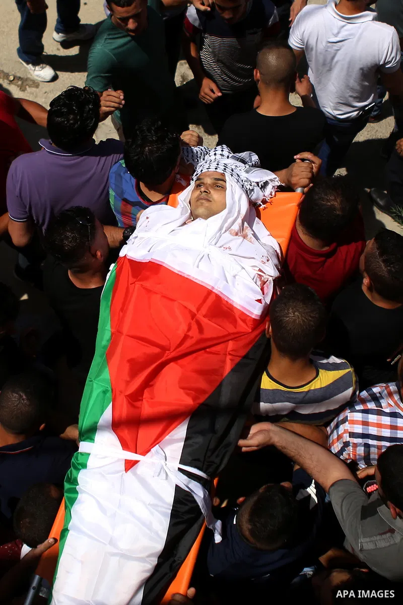 Mourners carry the body of 21-year-old Rafiq Taj, a Palestinian who was shot dead by Israeli forces after stabbing an Israeli border policeman, during his funeral procession on August 16, 2015 near the West Bank village...