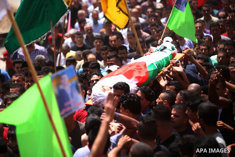 Mourners carry the body of 21-year-old Rafiq Taj, a Palestinian who was shot dead by Israeli forces after stabbing an Israeli border policeman, during his funeral procession on August 16, 2015 near the West Bank village...
