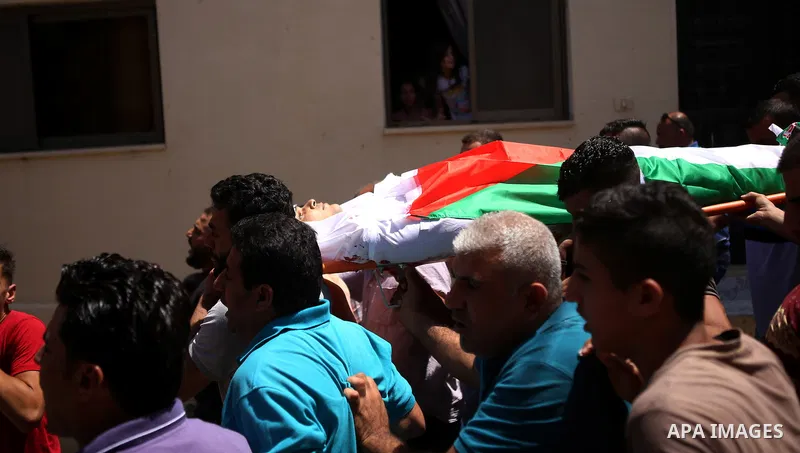 Mourners carry the body of 21-year-old Rafiq Taj, a Palestinian who was shot dead by Israeli forces after stabbing an Israeli border policeman, during his funeral procession on August 16, 2015 near the West Bank village...