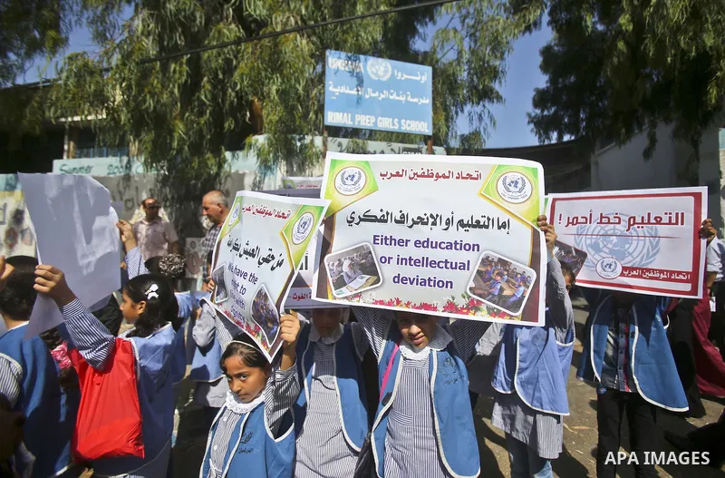 Palestinian children and teachers hold placards during a protest against the reduction of educational programs given by the United Nations Relief and Works Agency (UNRWA), in Gaza City August 17, 2015. Photo by Mohammed...