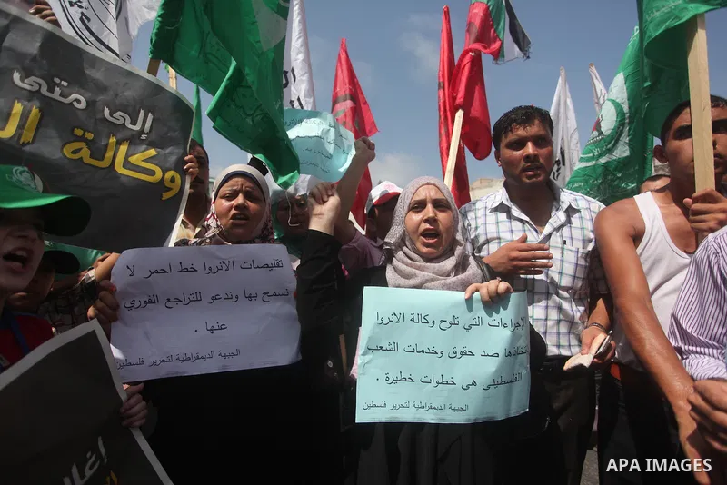 Palestinian children and teachers hold placards during a protest against the reduction of educational programs given by the United Nations Relief and Works Agency (UNRWA), in Gaza City August 17, 2015. Photo by Ashraf Am...