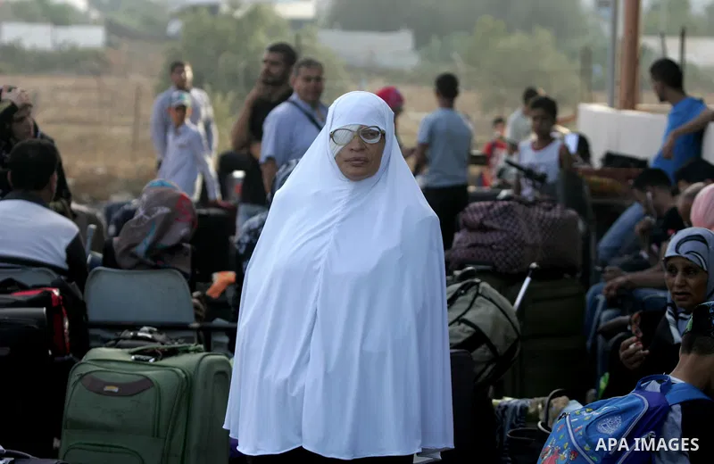 A woman waits for a travel permit to cross into Egypt at the Rafah border crossing between Egypt and the southern Gaza Strip August 18, 2015. Egypt opened the Rafah border crossing on Monday for four days to allow Palest...