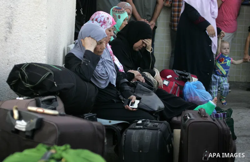 Palestinians wait for travel permits to cross into Egypt at the Rafah border crossing between Egypt and the southern Gaza Strip August 18, 2015. Egypt opened the Rafah border crossing on Monday for four days to allow Pal...
