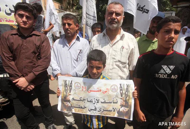 Palestinians hold placards during a protest to show solidarity with prisoner Mohammad Allan allegedly being held in an Israeli jail, in Gaza city on August 19, 2015. The Israeli military prosecutor intends to request cou...