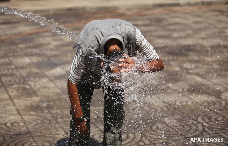 A Palestinian boy reacts as he splashes water on his head during a sweltering heat wave, in Gaza city on August 19, 2015. Photo by Ashraf Amra