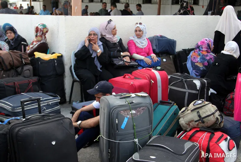 Palestinians wait for travel permits to cross into Egypt at the Rafah border crossing between Egypt and the southern Gaza Strip August 19, 2015. Egypt opened the Rafah border crossing on Monday for four days to allow Pal...