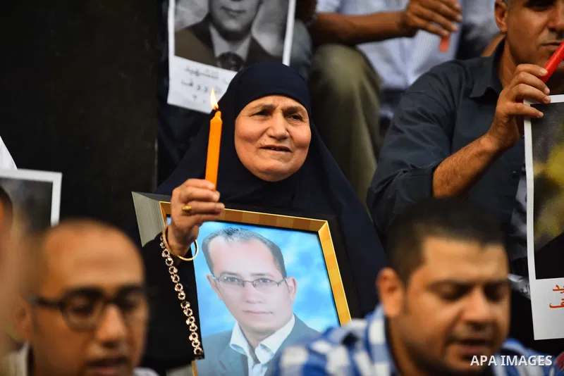 Relatives and friends of Egyptian journalist Tamer Abdel Raouf, hold his pictures during a protest marking the second anniversary of his death, in front of the journalists' syndicate in Cairo on August 19, 2015. Tamer Ab...