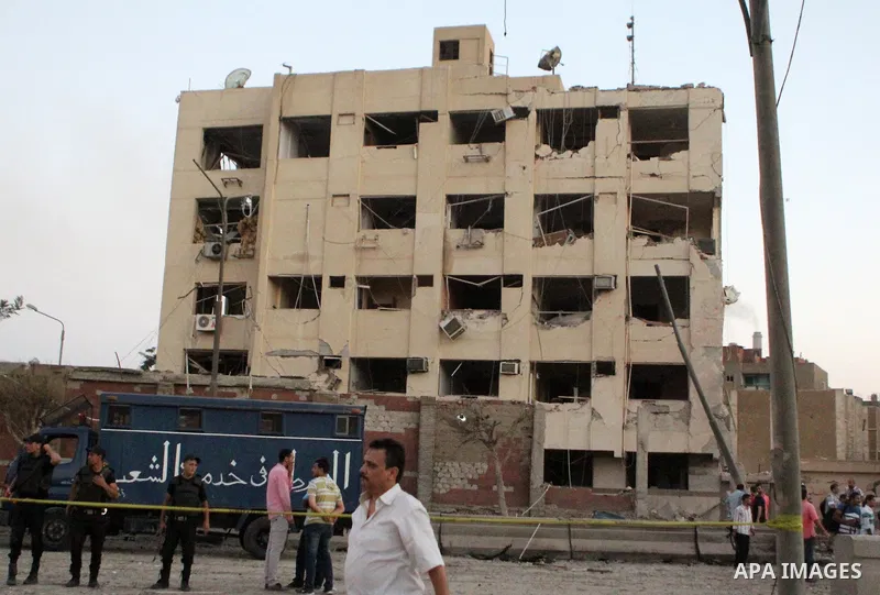Egyptians walk in front of the damaged national security building after a bomb exploded early Thursday, Aug. 20, 2015, in Shubra El-Kheima, Qaliubiya Governorate, on the outskirts of Cairo, Egypt August 20, 2015. At leas...