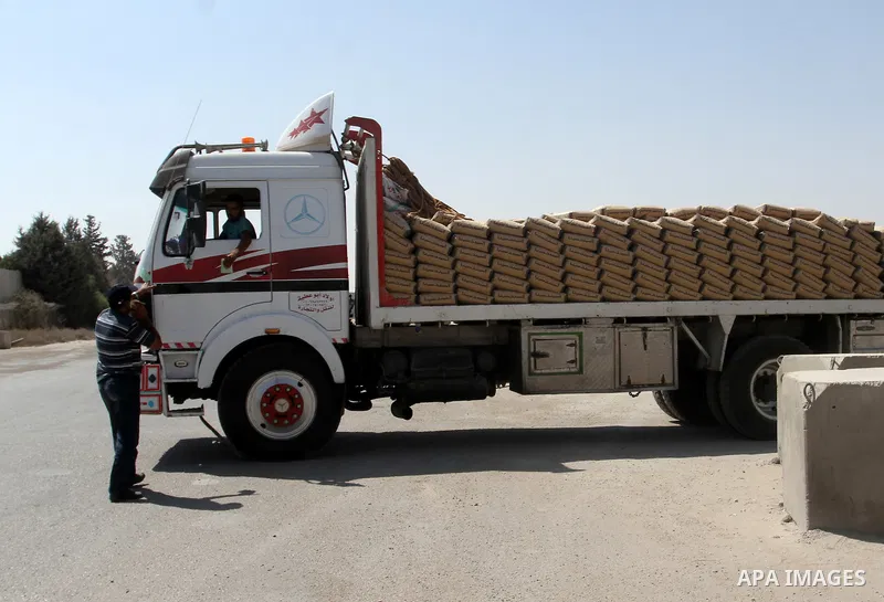 A Palestinian man walks next to a truck loaded with cement after it entered from Egypt through the Rafah border crossing in southern Gaza Strip, August 20, 2015. The authorities in Egypt have allowed 1,000 tons of cement...