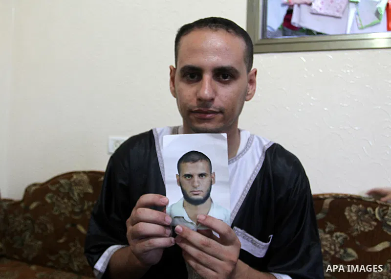 The brother of Yasser Zannoun, 27, holds his picture at their house in Rafah in the southern Gaza Strip, on August 20, 2015. Zannoun is one of four Palestinians were abducted in Egypt's Sinai Peninsula on Wednesday after...