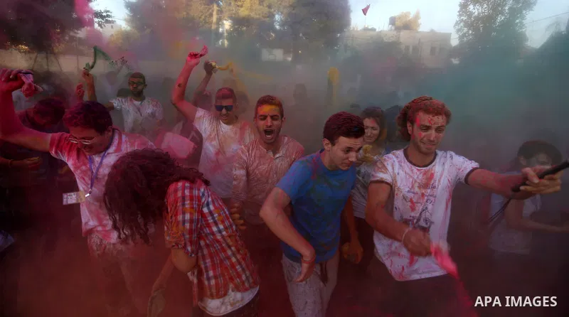Palestinian youths take part in the festival of colour battle in the West Bank city of Ramallah on August 20, 2015. Photo by Shadi Hatem